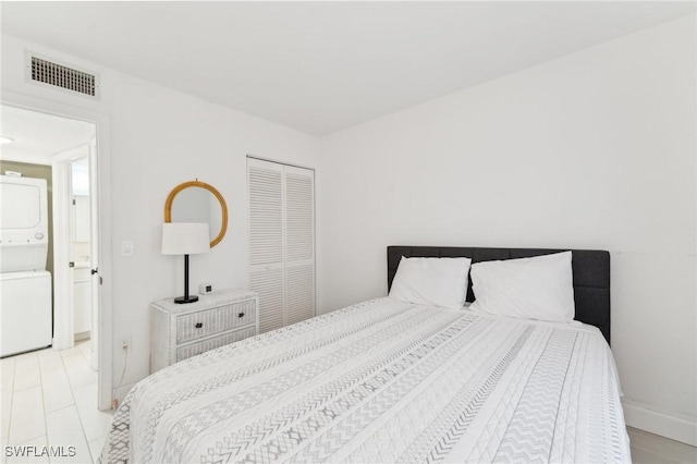 bedroom with stacked washer / drying machine and a closet