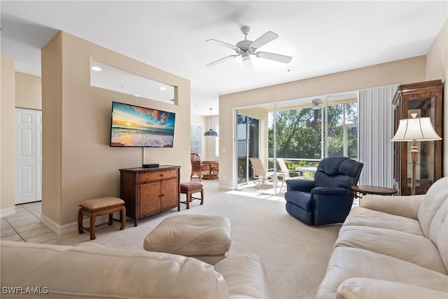 living room featuring light colored carpet, baseboards, and a ceiling fan