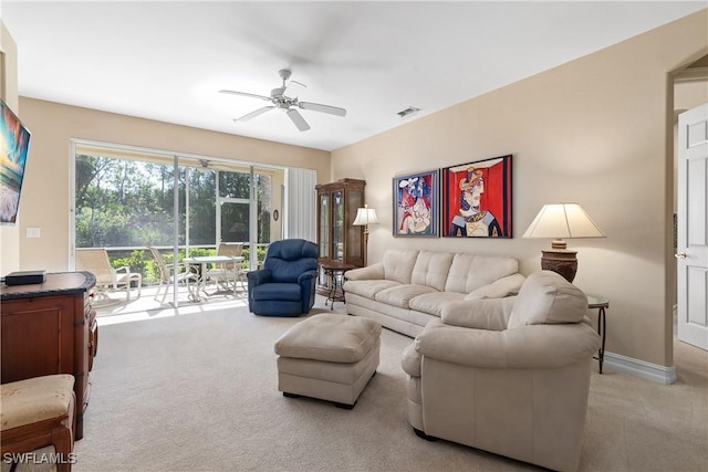 carpeted living room featuring visible vents, baseboards, and a ceiling fan