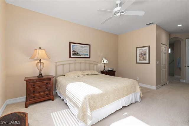 bedroom featuring baseboards, light carpet, recessed lighting, visible vents, and arched walkways
