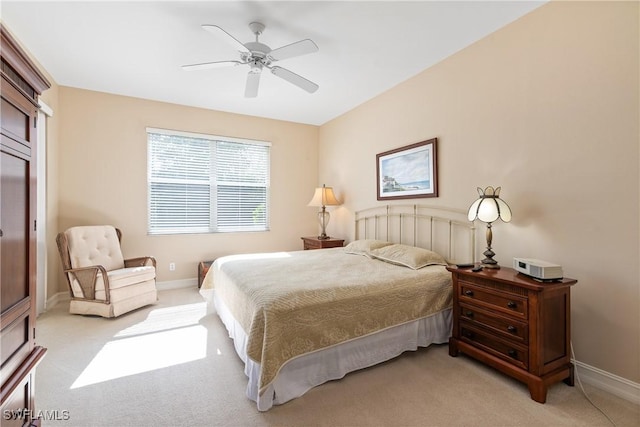 bedroom with light carpet, baseboards, and a ceiling fan