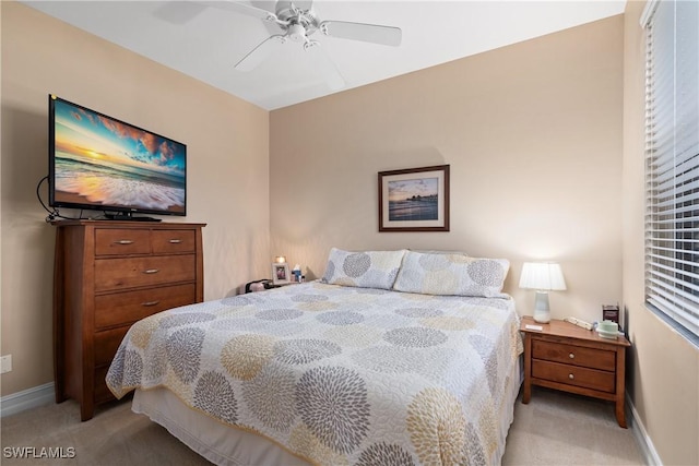 bedroom with ceiling fan, baseboards, and light carpet