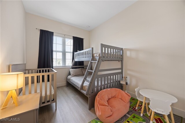 15901 Royal Pointe Ln Unit 404, Fort Myers, FL 33908 - bedroom with baseboards, vaulted ceiling, and wood finished floors