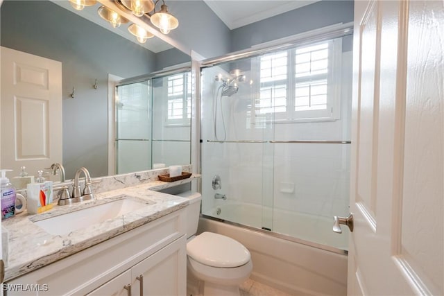 full bath featuring vanity, a wealth of natural light, toilet, and combined bath / shower with glass door