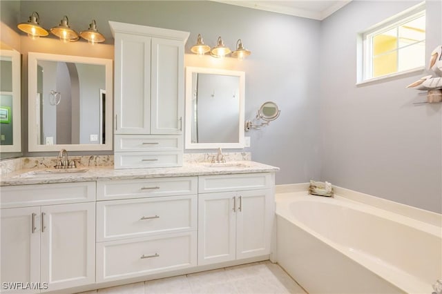 bathroom featuring double vanity, crown molding, a garden tub, and a sink