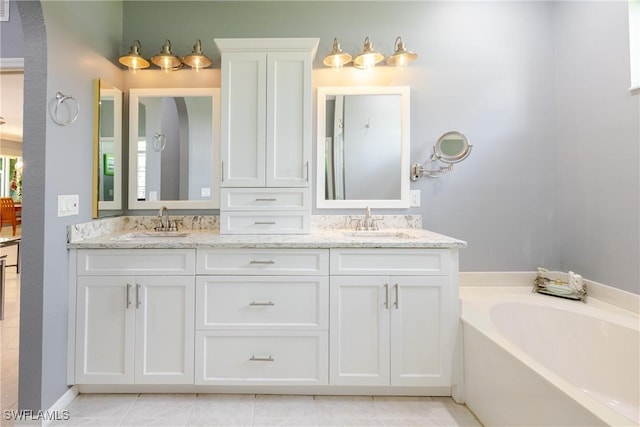 full bath featuring double vanity, a bath, and a sink