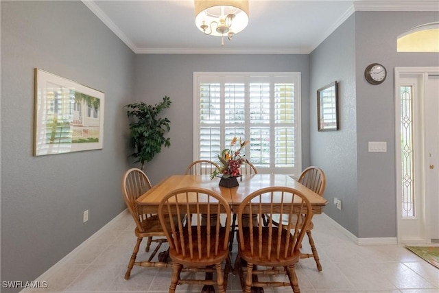 dining room featuring baseboards, crown molding, and light tile patterned flooring