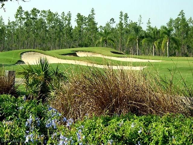 surrounding community with golf course view and a lawn