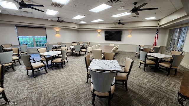 carpeted dining room featuring ceiling fan, visible vents, and a drop ceiling