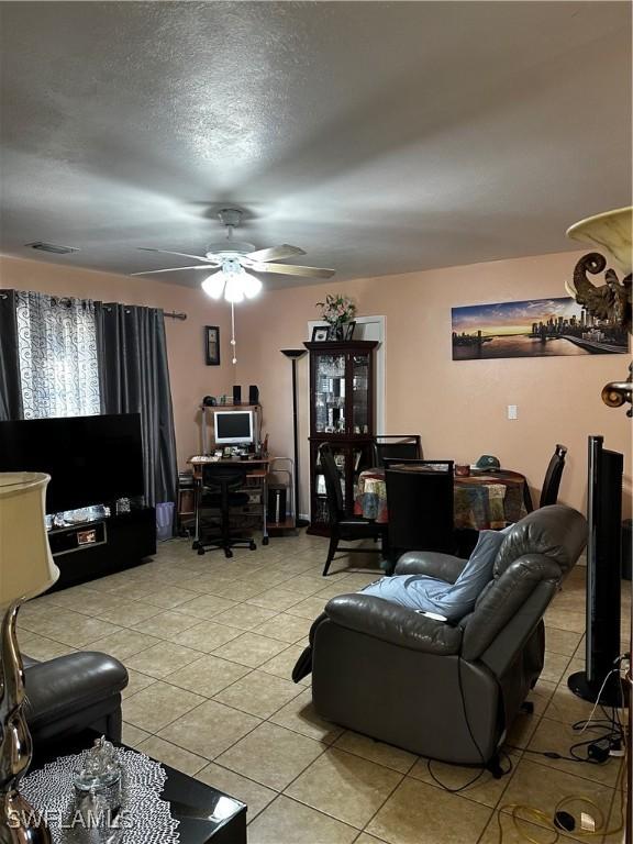 110 Clayton Ave, Lehigh Acres, FL 33936 - living room with a textured ceiling, light tile patterned flooring, ceiling fan, and visible vents