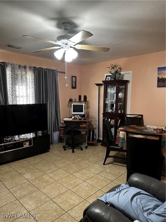 110 Clayton Ave, Lehigh Acres, FL 33936 - home office with light tile patterned floors, a ceiling fan, and visible vents