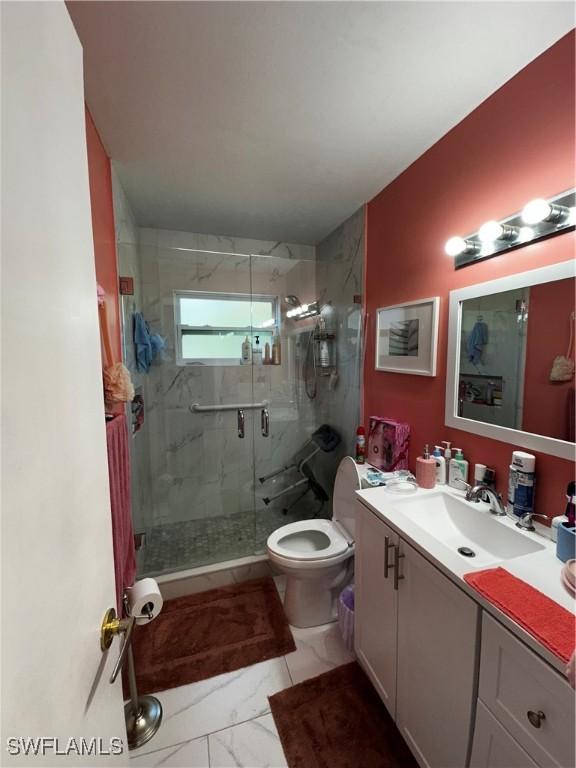 110 Clayton Ave, Lehigh Acres, FL 33936 - bathroom with toilet, a shower stall, marble finish floor, and vanity