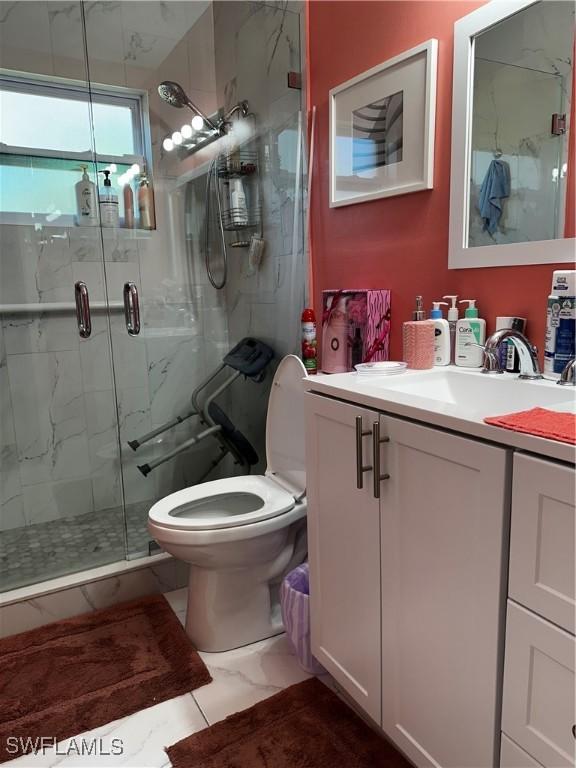110 Clayton Ave, Lehigh Acres, FL 33936 - bathroom featuring toilet, marble finish floor, vanity, and a marble finish shower