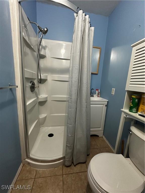 110 Clayton Ave, Lehigh Acres, FL 33936 - bathroom featuring a shower stall, a sink, tile patterned flooring, and toilet