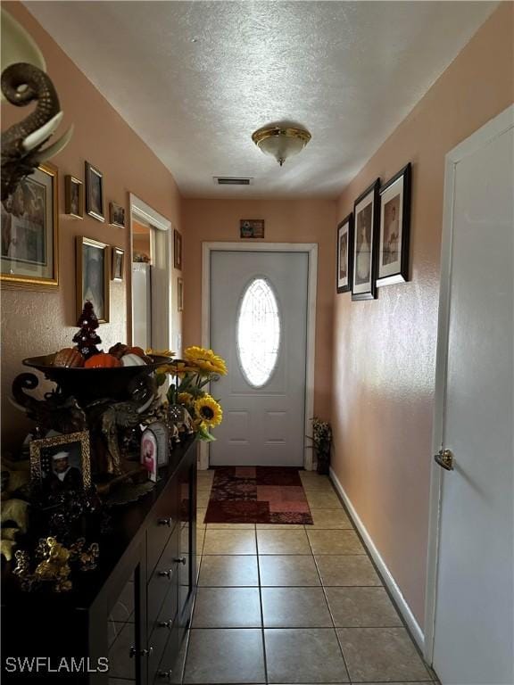 110 Clayton Ave, Lehigh Acres, FL 33936 - entryway featuring light tile patterned floors, baseboards, visible vents, and a textured ceiling