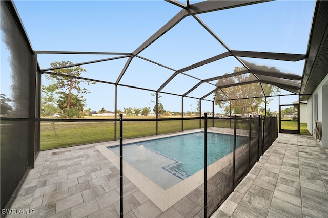 outdoor pool with a yard, a patio area, and glass enclosure