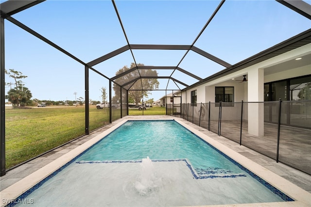 outdoor pool featuring a lanai, a patio, a ceiling fan, and a lawn
