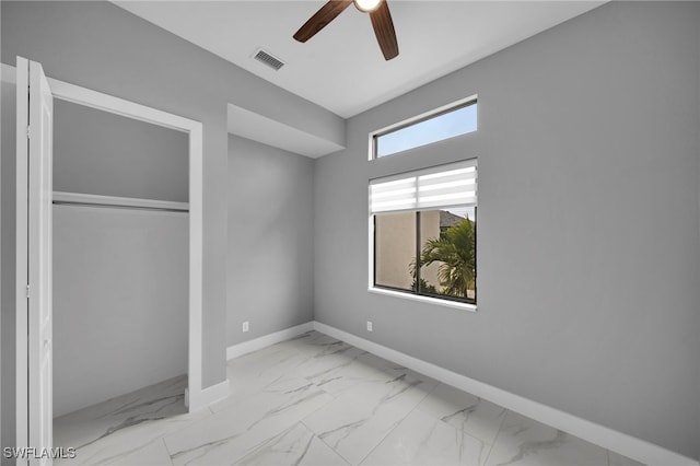 unfurnished bedroom with marble finish floor, baseboards, a ceiling fan, and visible vents