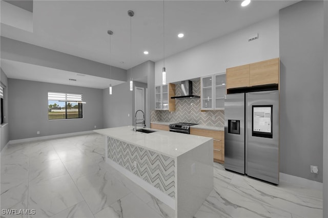 kitchen featuring wall chimney exhaust hood, tasteful backsplash, marble finish floor, a sink, and stainless steel appliances