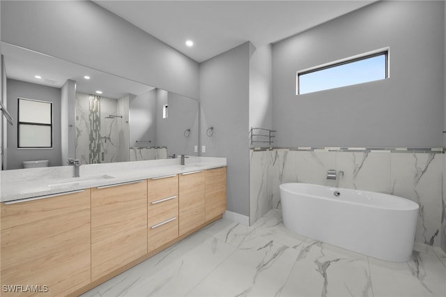 full bathroom with a freestanding tub, marble finish floor, a sink, a marble finish shower, and double vanity