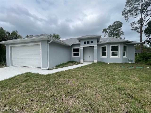 prairie-style house with a front yard, driveway, stucco siding, and an attached garage