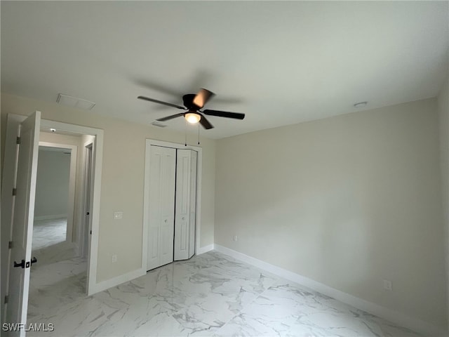unfurnished bedroom featuring a closet, baseboards, visible vents, ceiling fan, and marble finish floor