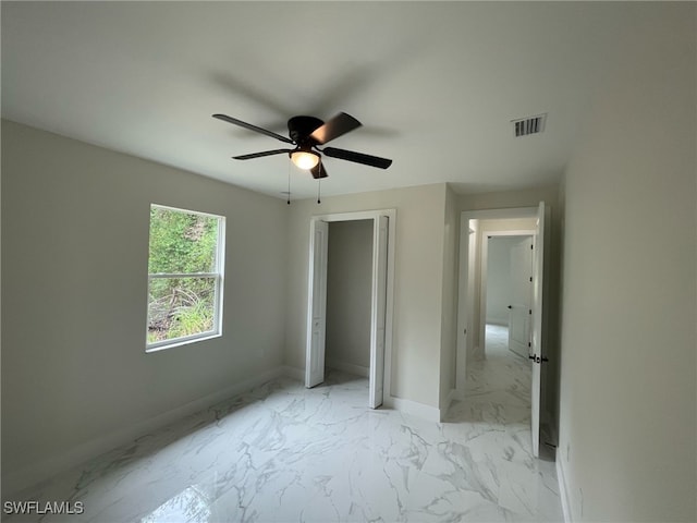 unfurnished bedroom featuring a closet, baseboards, visible vents, ceiling fan, and marble finish floor