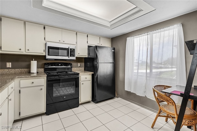 11170 Caravel Cir Unit 210, Fort Myers, FL 33908 - kitchen with black appliances, light tile patterned floors, a tray ceiling, light countertops, and white cabinets