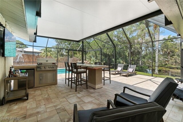 view of patio featuring a lanai, grilling area, outdoor dry bar, and area for grilling
