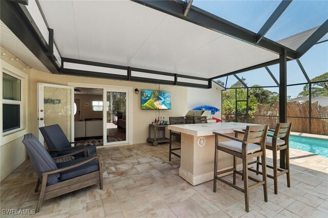 view of patio / terrace with a fenced in pool, a lanai, and outdoor dry bar