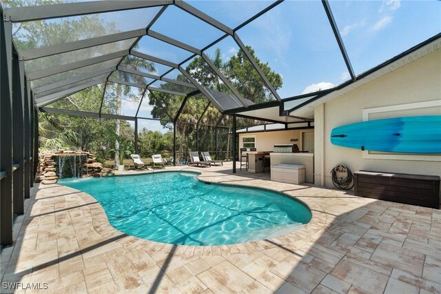 pool with glass enclosure and a patio area