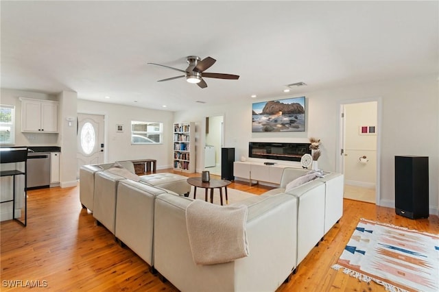 living area with a ceiling fan, visible vents, a healthy amount of sunlight, and light wood-style flooring