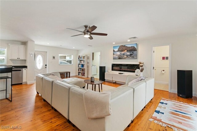 living area with a ceiling fan, visible vents, a healthy amount of sunlight, and light wood-style flooring