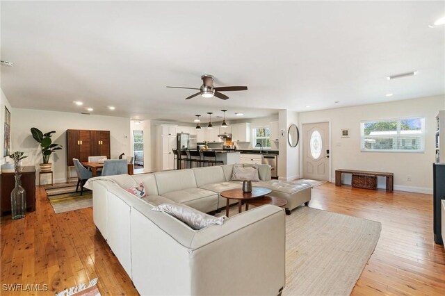 living area with recessed lighting, light wood finished floors, ceiling fan, and a wealth of natural light