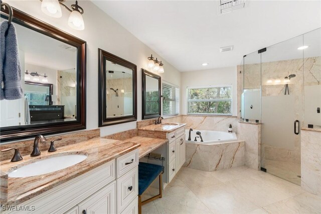 full bathroom featuring vanity, a shower stall, a bath, and visible vents