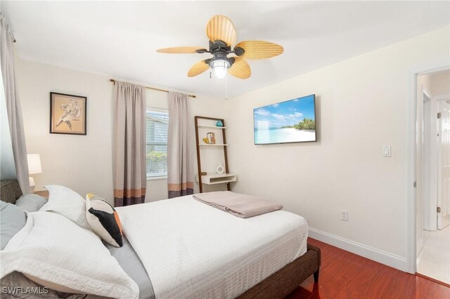 bedroom with baseboards, ceiling fan, and wood finished floors