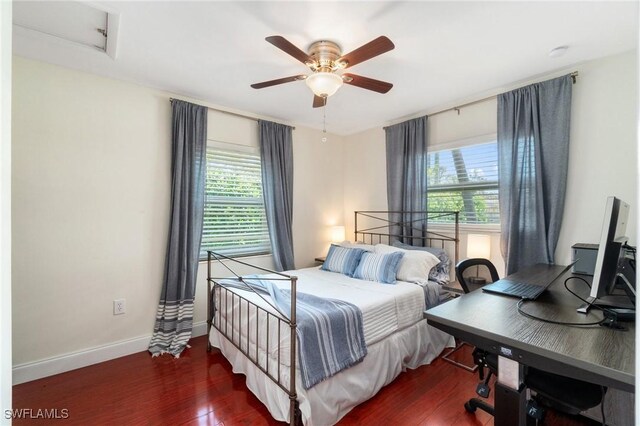 bedroom with baseboards, wood finished floors, and multiple windows