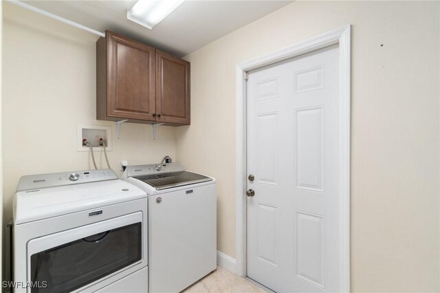 washroom featuring cabinet space and washer and clothes dryer