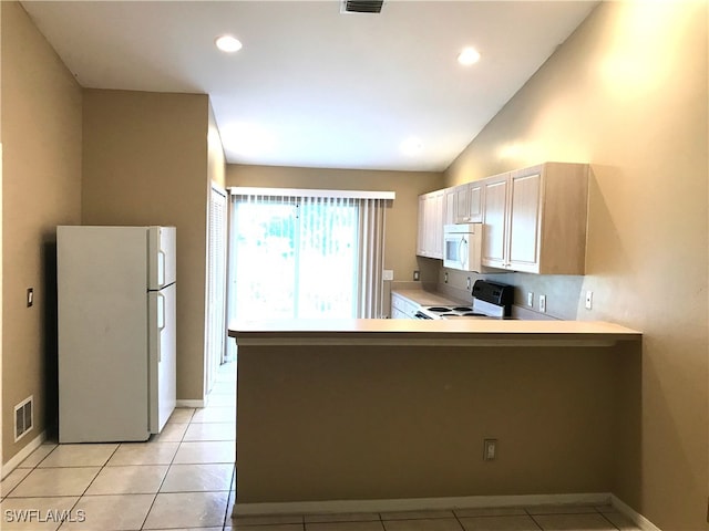 kitchen with visible vents, light tile patterned floors, light countertops, white appliances, and a peninsula