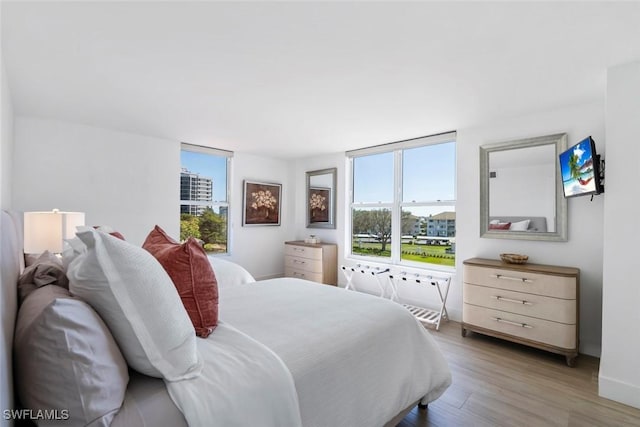 bedroom featuring multiple windows and wood finished floors