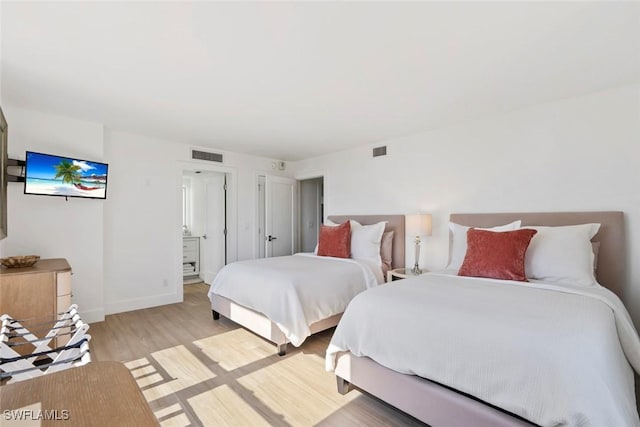 bedroom featuring visible vents, baseboards, and light wood finished floors
