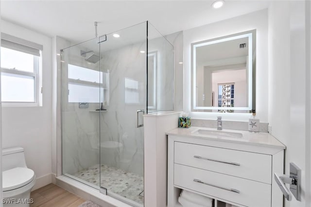 full bath featuring a marble finish shower, toilet, and vanity