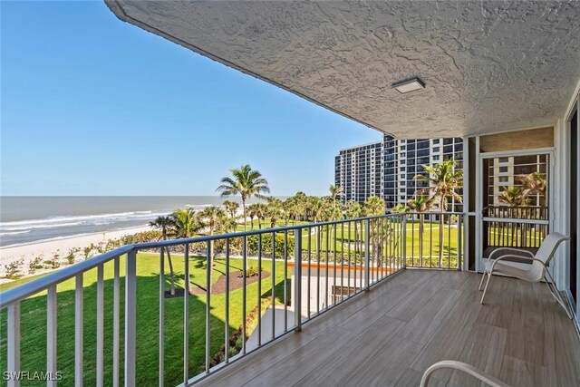 balcony featuring a water view and a beach view