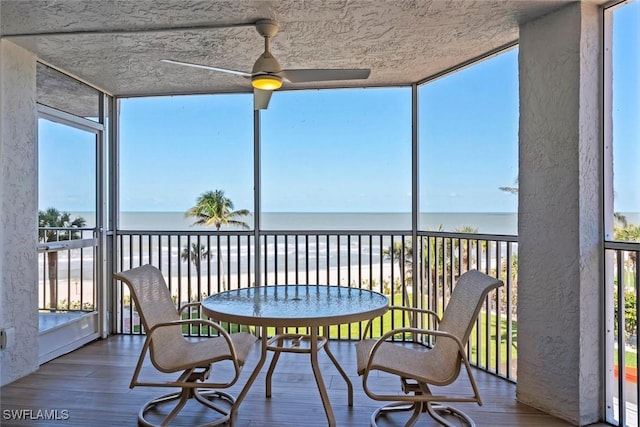 sunroom with a water view, wood finished floors, and floor to ceiling windows