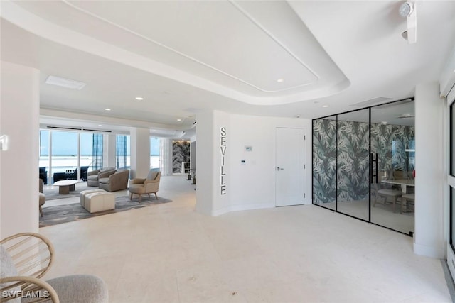 living room with recessed lighting and a tray ceiling