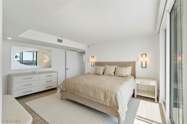 bedroom featuring visible vents and wood finished floors