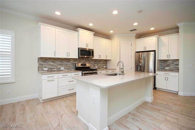 kitchen with appliances with stainless steel finishes, a sink, backsplash, ornamental molding, and recessed lighting