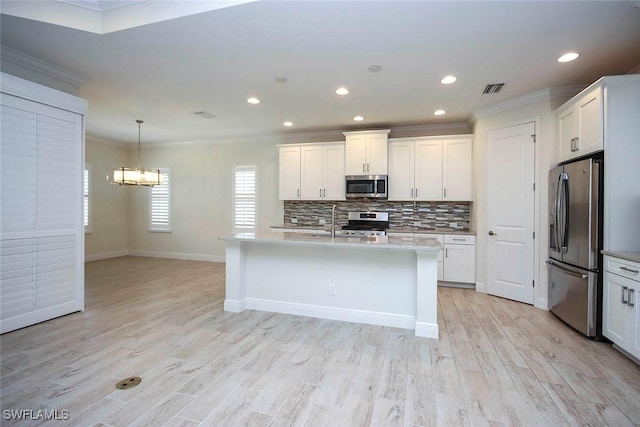 kitchen featuring stainless steel appliances, ornamental molding, light countertops, a chandelier, and a sink