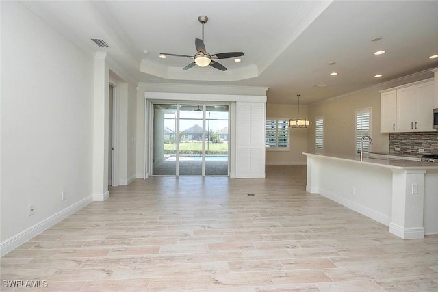 kitchen featuring crown molding, open floor plan, ceiling fan, recessed lighting, and light countertops