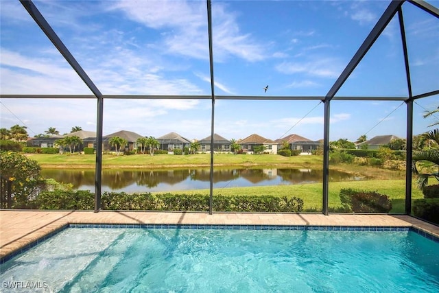 swimming pool featuring a water view, a residential view, a lanai, and a yard
